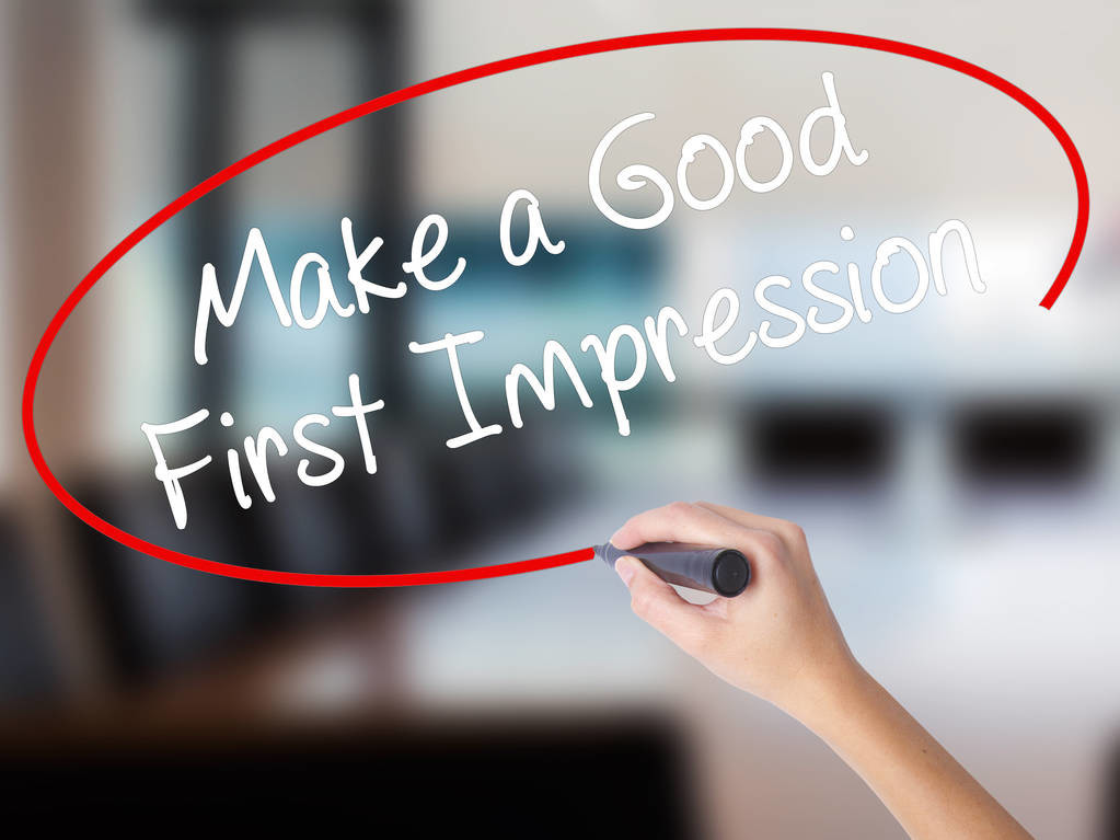 Woman Hand Writing Make a Good First Impression with a marker ov